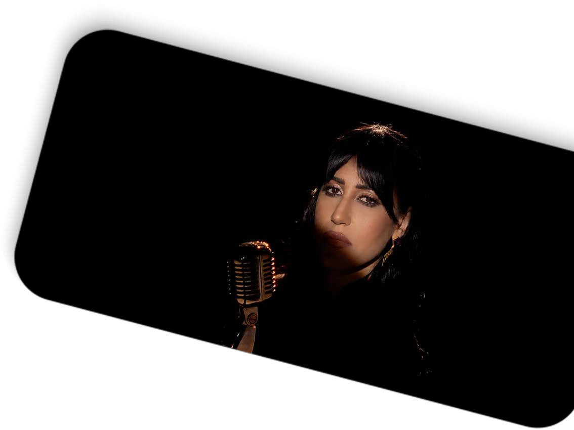 Marwa Amin beside a microphone against a dark background