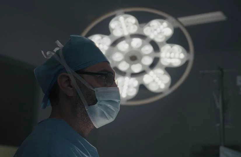 A surgeon working under operating lights